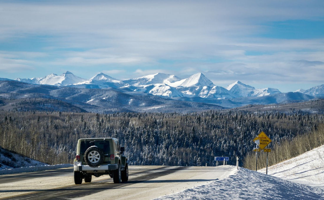 Winter mountain road with Rocky Mountains in a background
