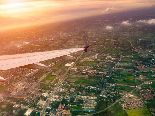 Air plane wing flying above the clearly sky at sunset