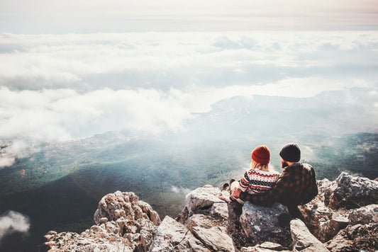 Couple travelers Man and Woman sitting on cliff relaxing mountains