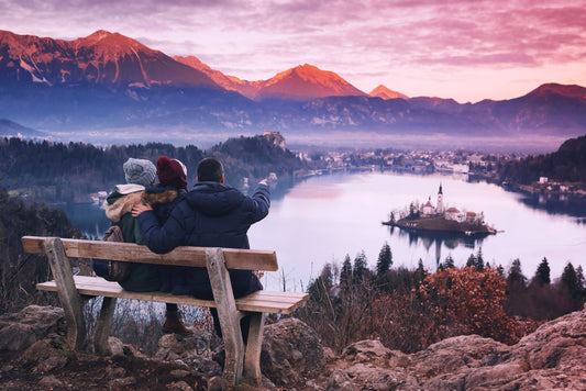 Top view on Island with Catholic Church in Bled Lake with Castle and Alps Mountains in Background