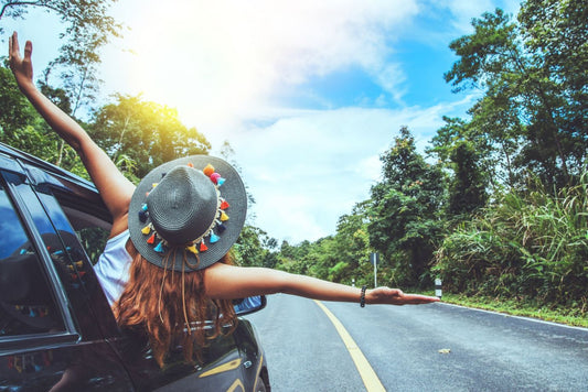 girl enjoying summer outside a car window