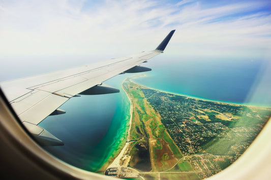 photo through a window out of an airplane looking at a beach