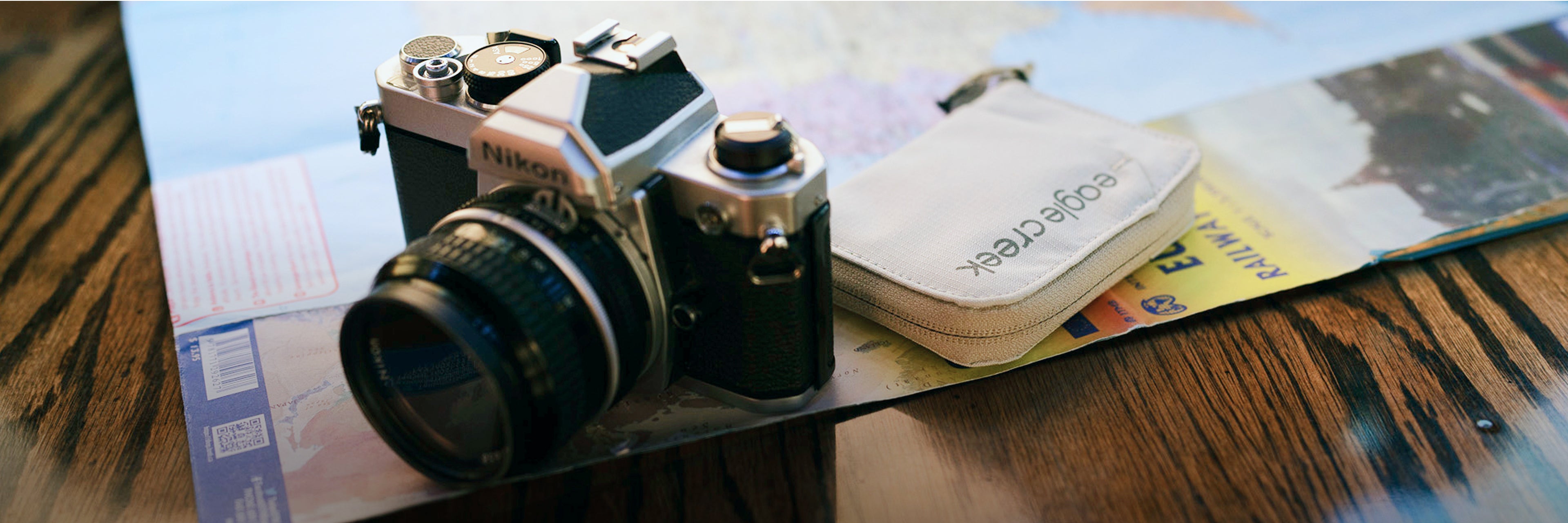 An Eagle Creek Wallet and Nikon camera on a table