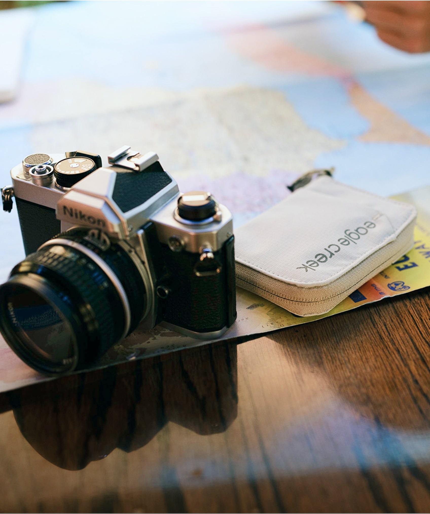 An Eagle Creek Wallet and Nikon camera on a table