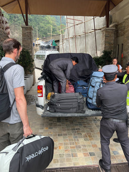 People unloading a truck full of luggage and Eagle Creek duffles