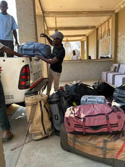 Two people unloading a truck full of Eagle Creek duffle bags