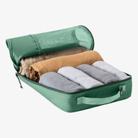 Green packing cube with rolled-up clothes inside