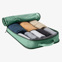 Green travel packing cube with rolled clothes inside 