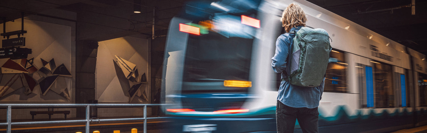 A man waits for the subway with an Eagle Creek backpack