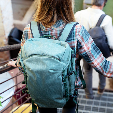 A woman wearing a green travel backpack