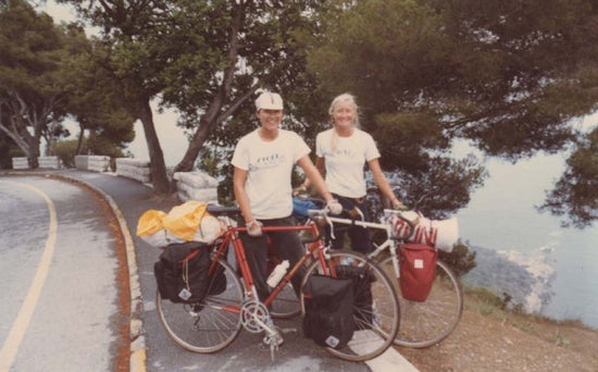 Two smiling women with loaded bicycles