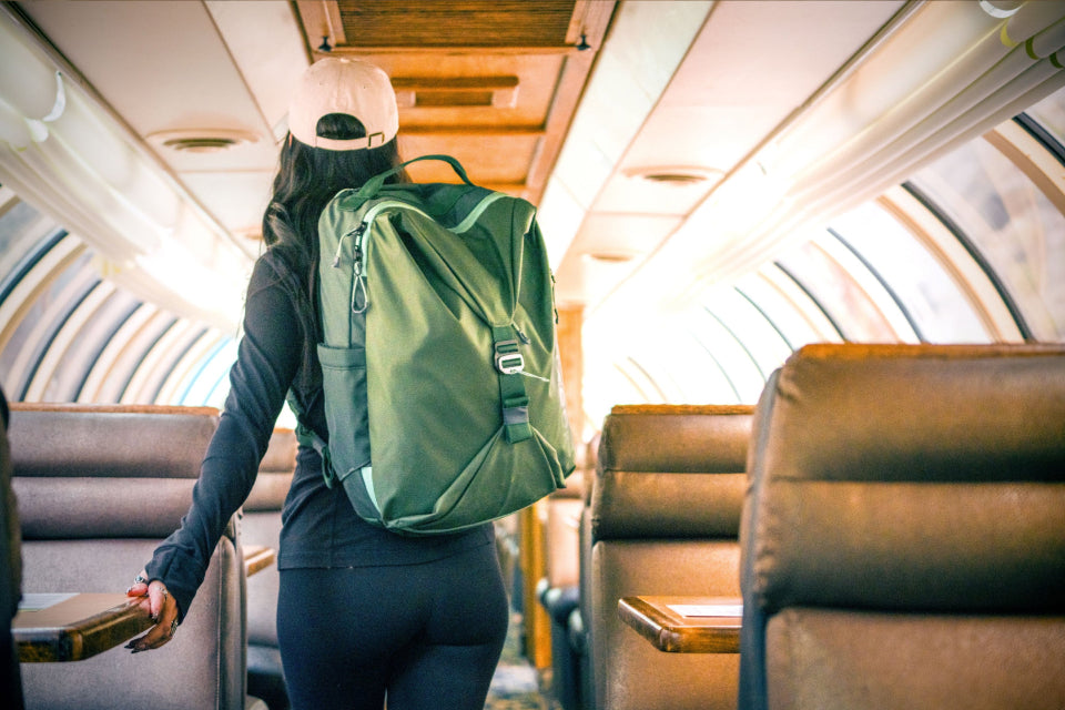 A woman boards a train wearing an Eagle Creek Travel Backpack