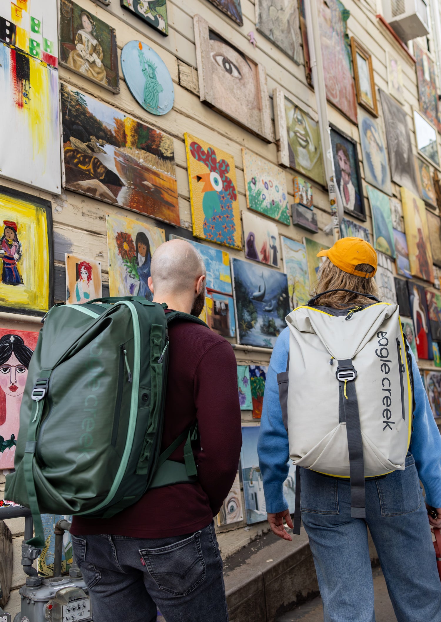 Two people admiring artwork while wearing Eagle Creek travel backpacks