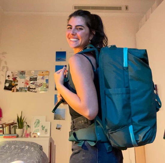 A woman wearing a travel backpack preps for an adventure